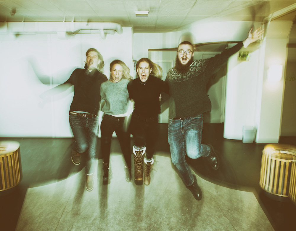 Fyra skådespelare hoppar tillsammans mot kameran